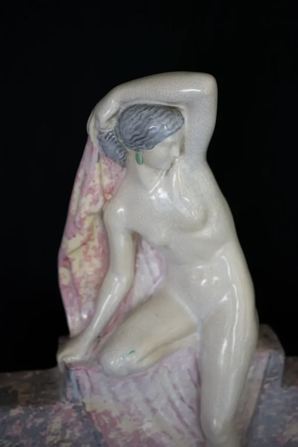Femme nue drapée assise par Fanny Rozet. Sujet lumineux en céramique polychrome avec ses luminaires en biscuit. Vue sur la femme nue, portrait.