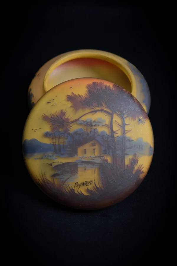 Bonbonnière en verre jaune/orangé signée Jean-Simon Peynaud avec couvercle ouvert, posé sur le devant de la bonbonnière. Format portrait.