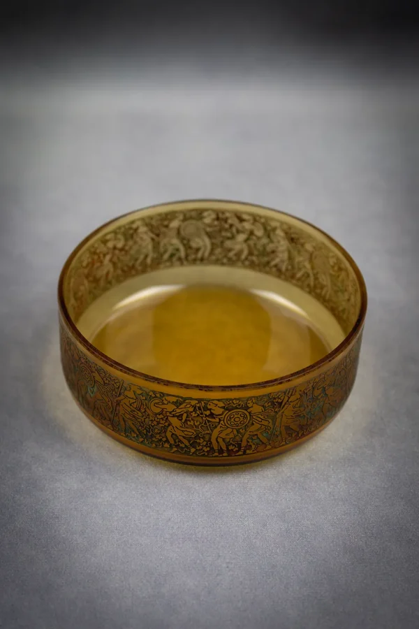 Coupe en verre ambré Moser à décor gravé d'amazones, de dessus, format portrait.