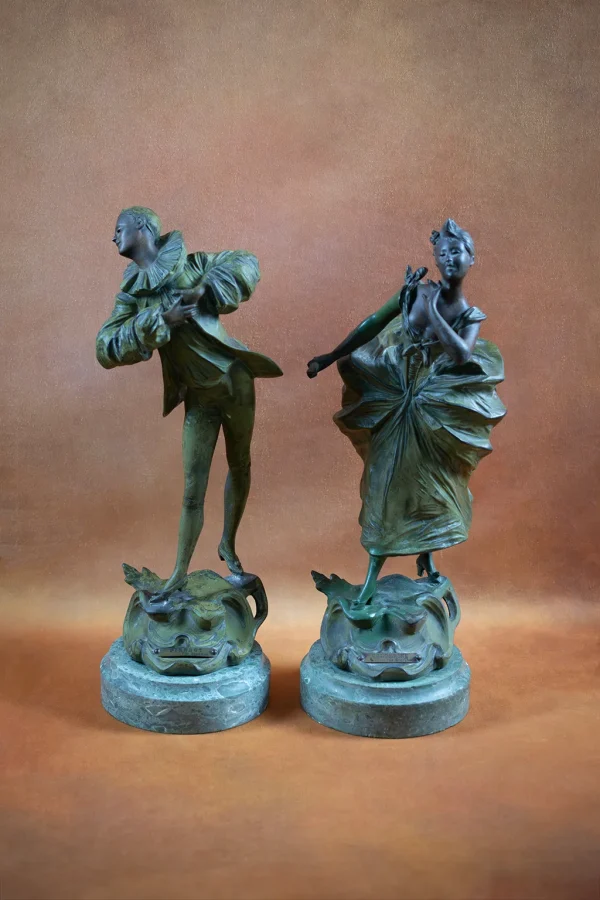 Pierrot et Colombine. Deux sujets en régule polychrome sur socles ronds en faux marbre de Victor Léopold BRUYNEEL - Vue de face, Pierrot à gauche, Colombine à droite. Format portrait.