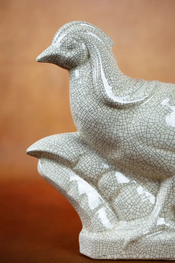 Détail du craquelé de la faïence sur la sculpture de faisan.