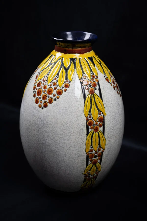 Vue de trois-quarts du vase en faïence craquelée, à décor de baie et de feuille de Charles Catteau