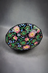Coupe Émaux de Longwy vue de dessus, décor floral polychrome sur fond noir, inclinée.