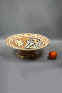 Vue de profil de la coupe Keraluc de Jos Le Corre sur pied avec une mandarine pour l’échelle