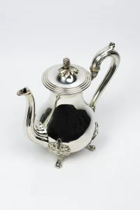 Théière Christofle métal argenté vue plongeante trois quarts, profil piriforme et pieds rocaille