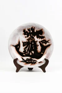 Assiette céramique Jean Lurçat « Les Sirènes » Sant Vicens, décor bestiaire hybride noir sur fond blanc marbré brun, vue de face sur présentoir