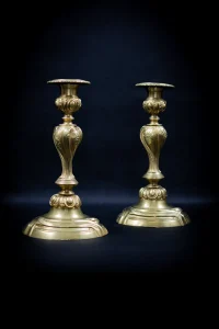 Paire de flambeaux en bronze doré vue de trois quarts, décor rocaille acanthe et coquilles