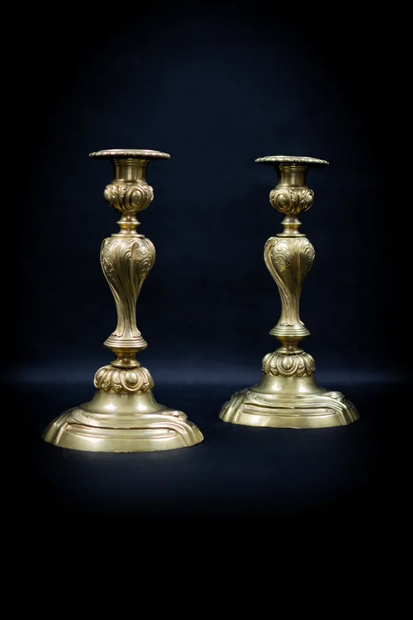 Paire de flambeaux en bronze doré vue de trois quarts, décor rocaille acanthe et coquilles
