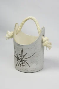 Vue trois-quarts du seau à glaçons en céramique émaillée d'Henri Cimal, anse tressée et nœuds frangés visibles